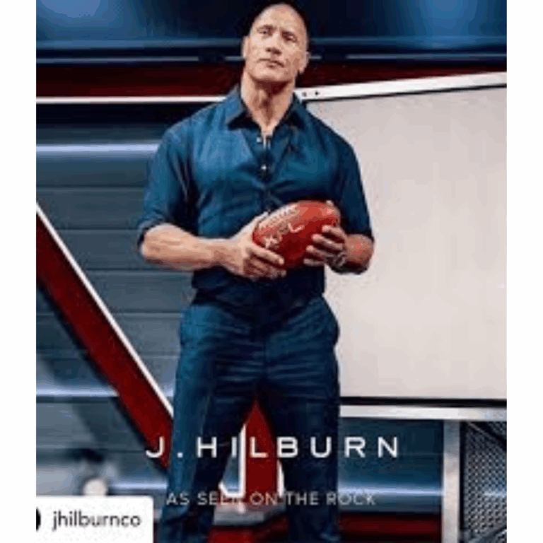 Dwayne “The Rock” Johnson wearing a fitted navy J.Hilburn outfit, holding a football during the XFL Draft with the J.Hilburn logo and "As Seen On The Rock" branding.